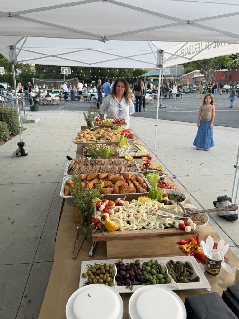 A long table of appetizers under a white tent