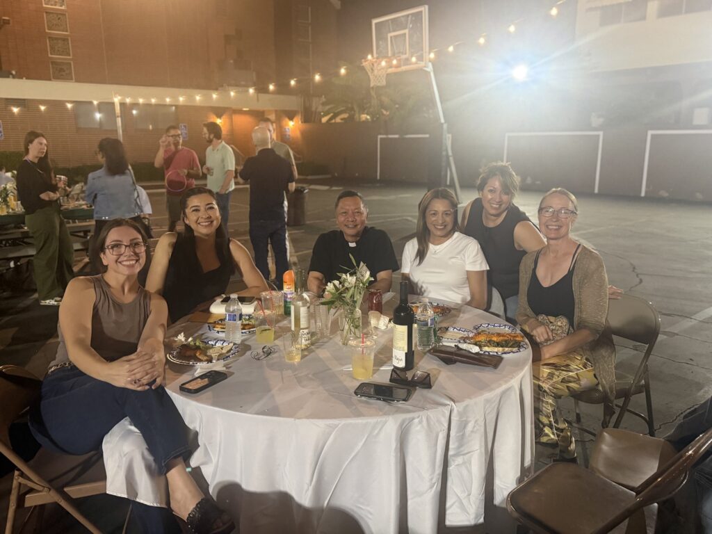 A group of parents smiling around a round dinner table