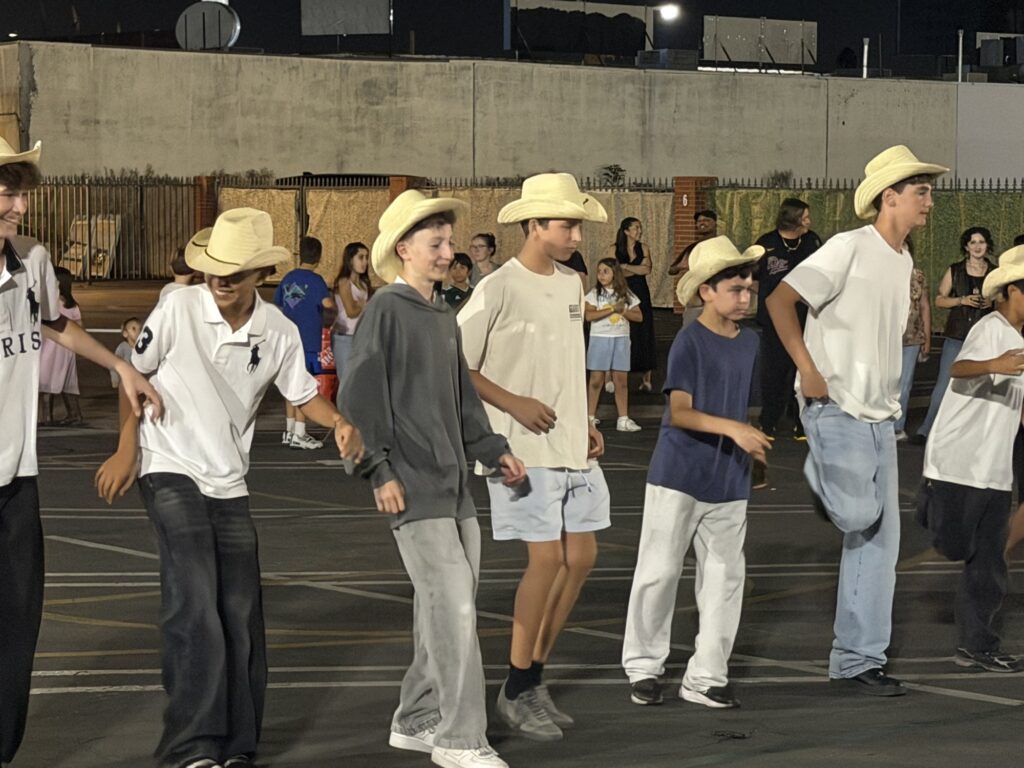 A line of dancers in cowboy hats