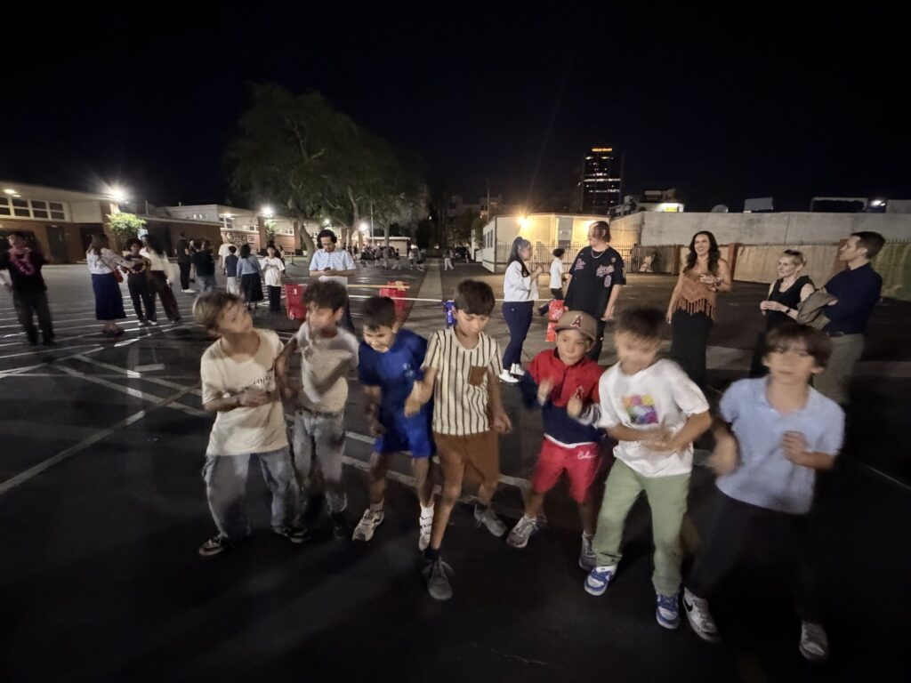 A group of kids dancing and laughing together at night