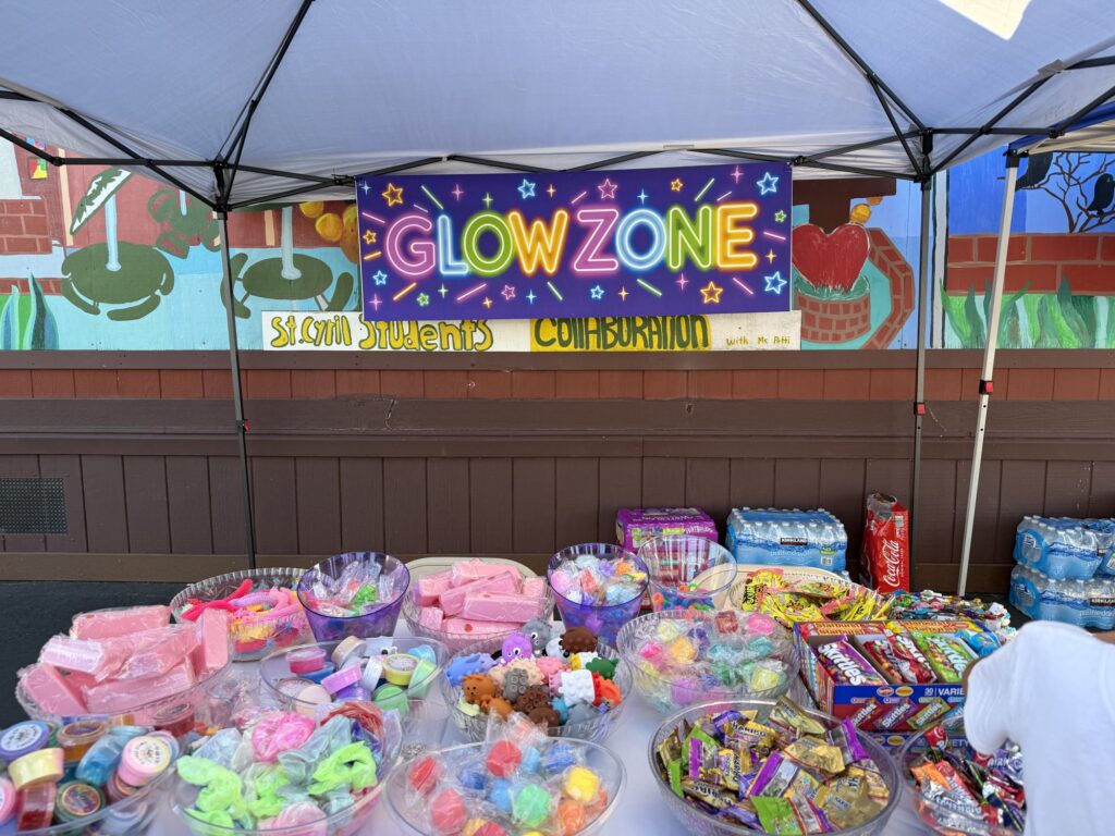 A table of glow sticks and prizes under the Glow Zone banner