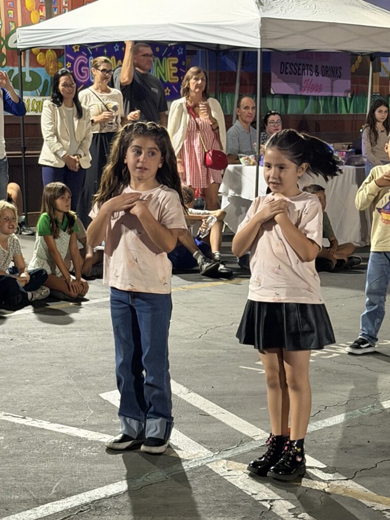 Two girls standing side by side, ready to dance