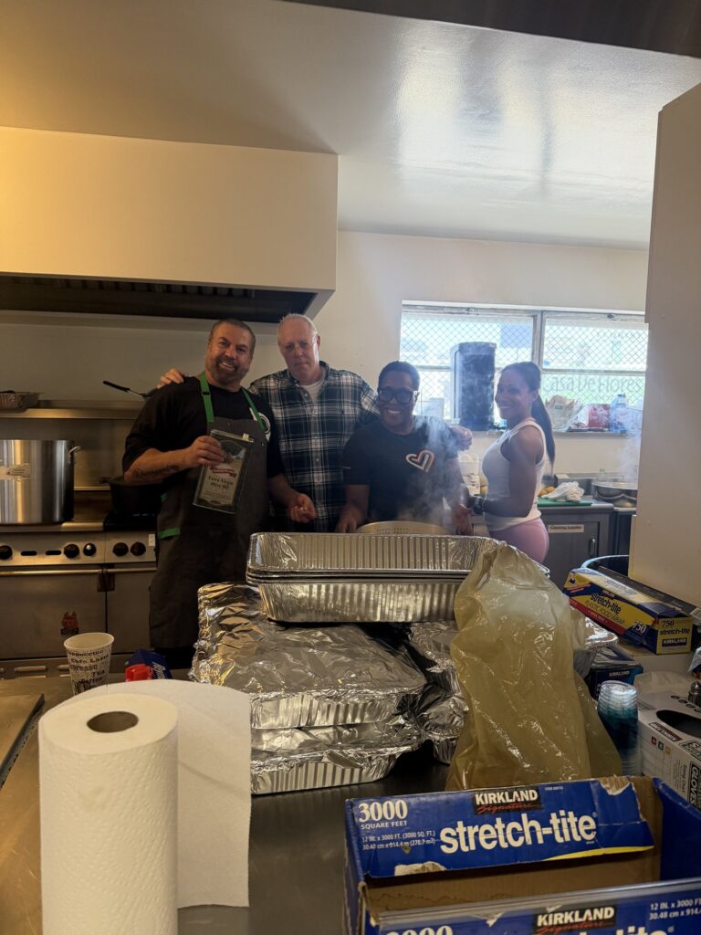Volunteers in the school kitchen preparing trays of food
