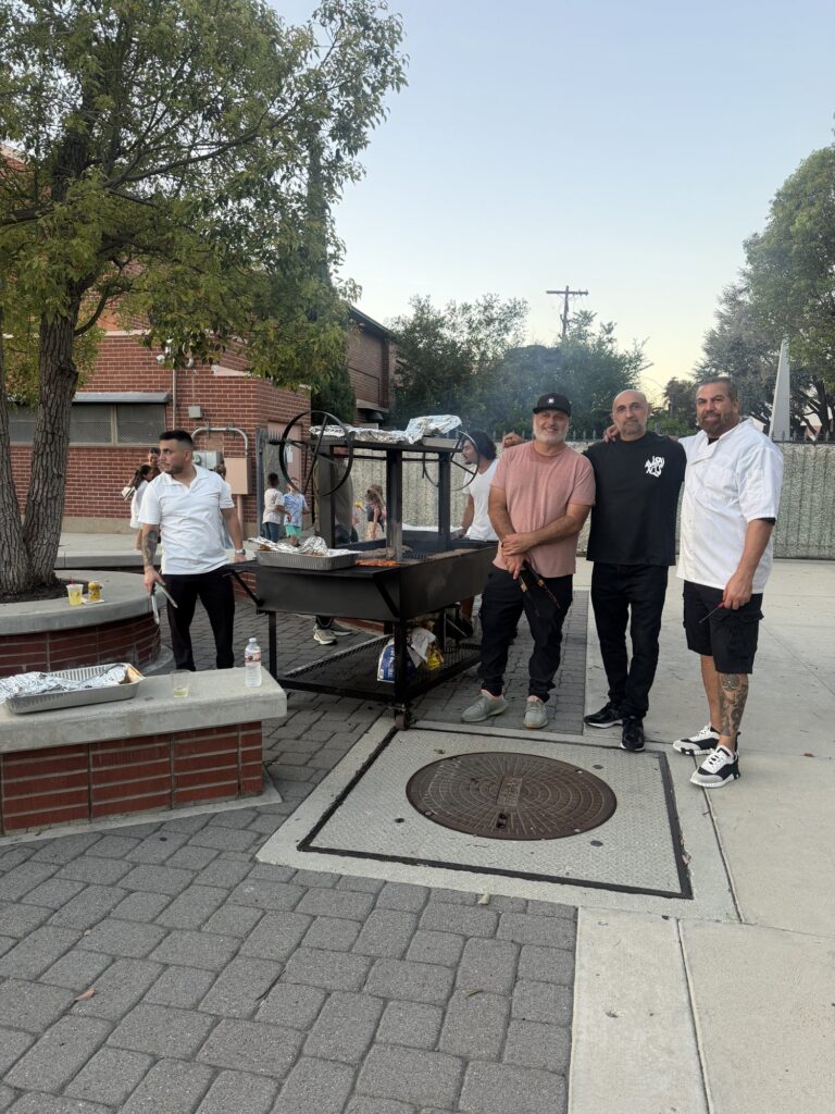 Grill volunteers standing by the barbecue before the event