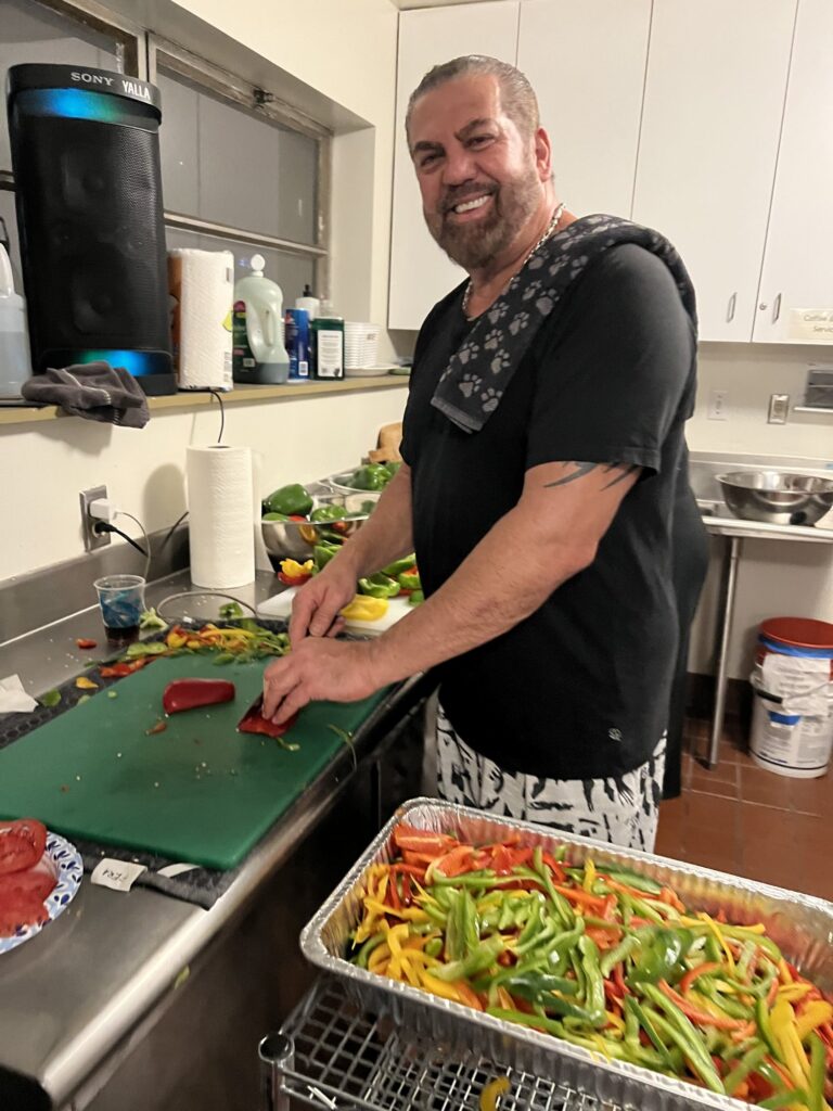 A volunteer chopping peppers in the school kitchen